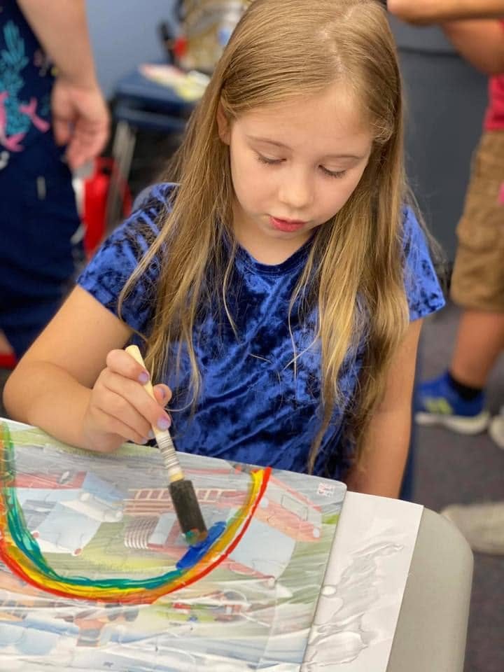 A member painting during a program activity